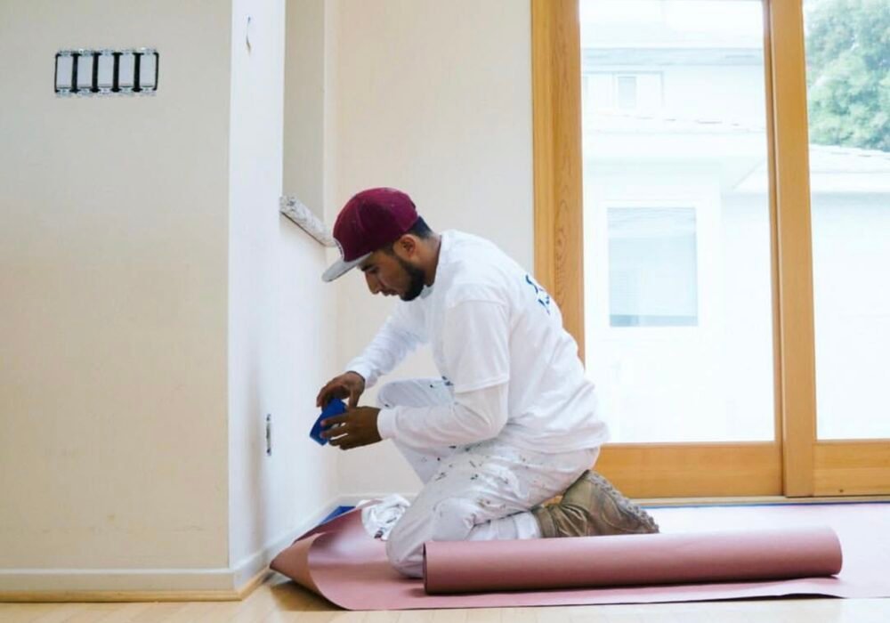 Painter preparing interior wall for painting