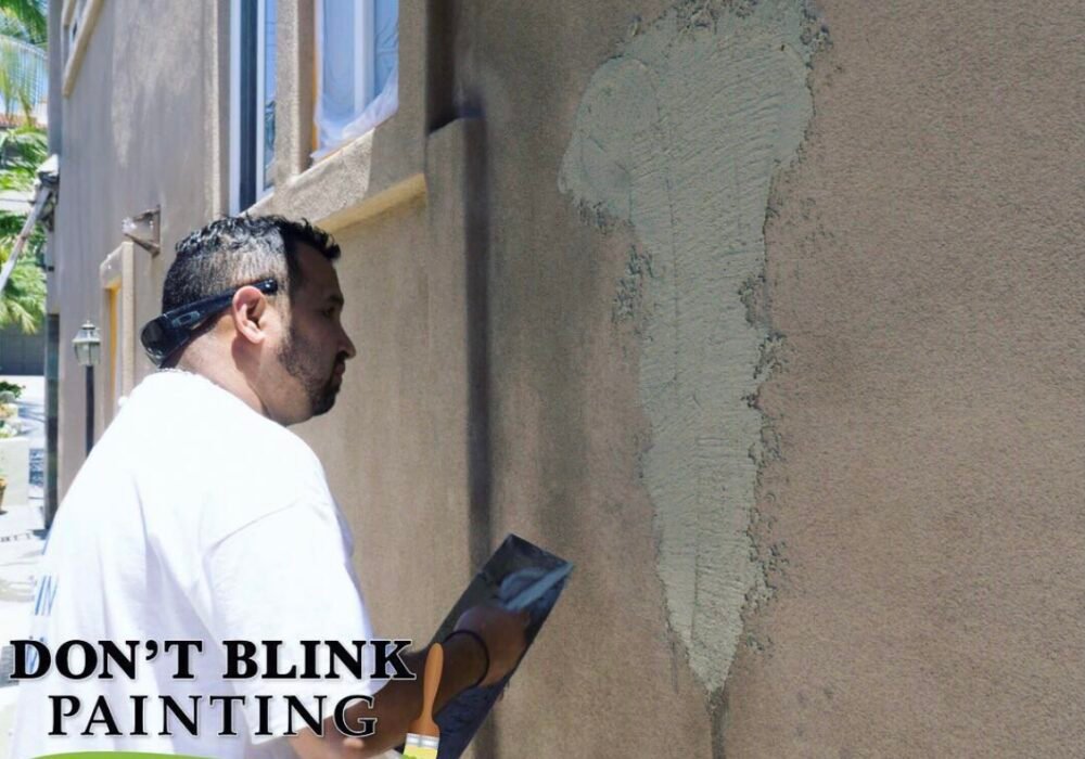 Painter repairing exterior stucco wall surface